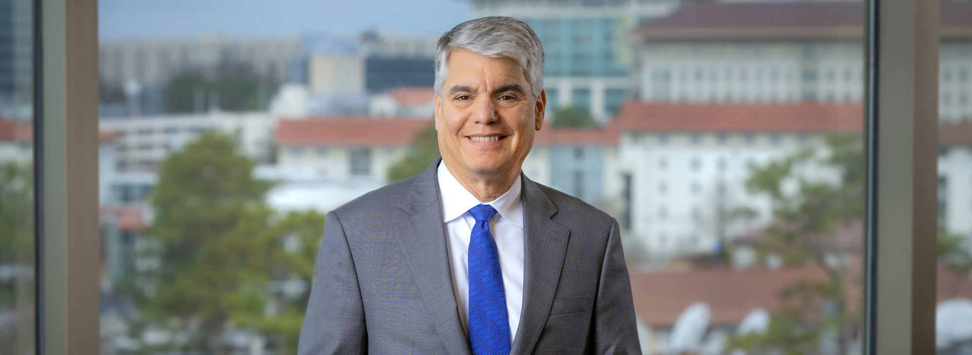 Gregory L. Fenves standing in Convocation Hall with Emory University visible behind him in the window