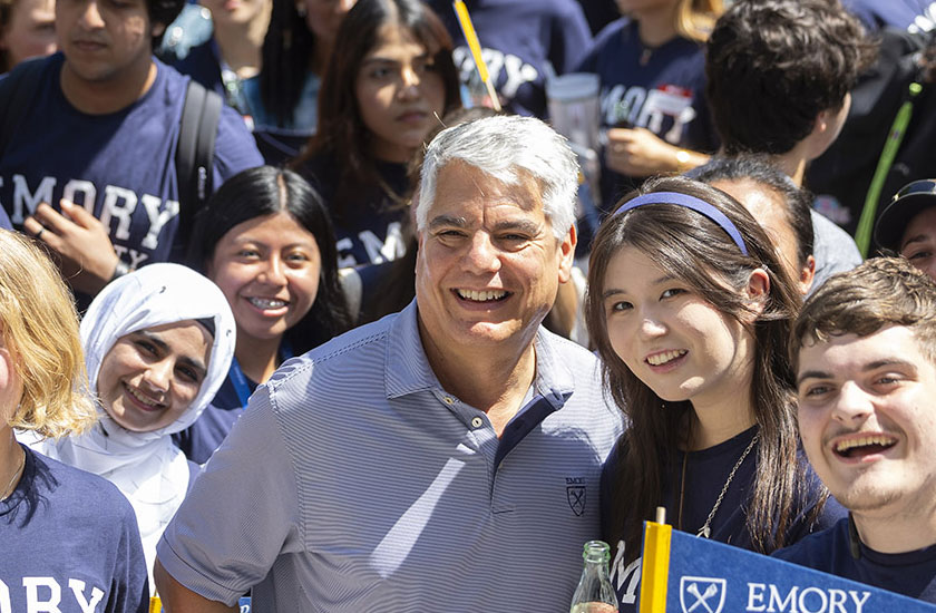 president fenves poses with students in Emory tshirts and with Emory pennants