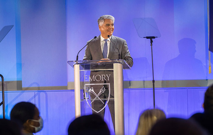 president fenves gives a speech from a podium with a bright blue background 