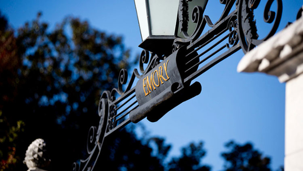 close up of emory main gate with blue sky behind