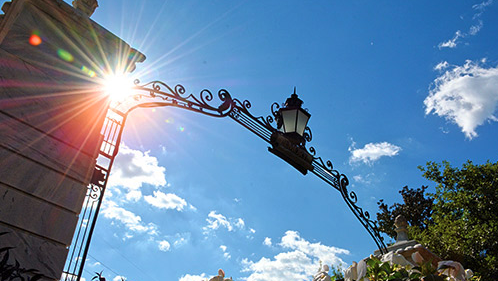 main gates against blue sky with sun flare